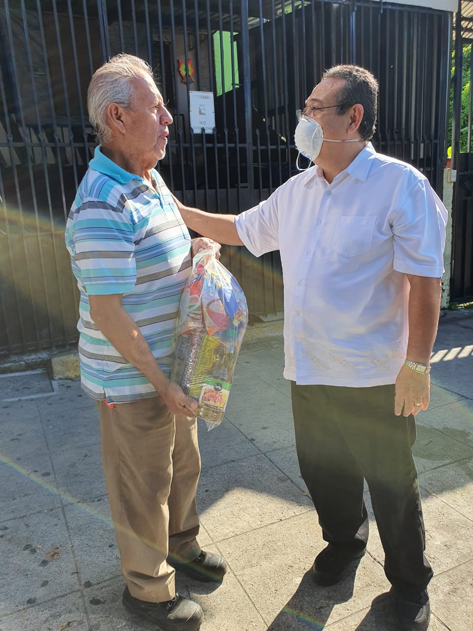 Praying for a man with a bag of donated food in El Salvador
